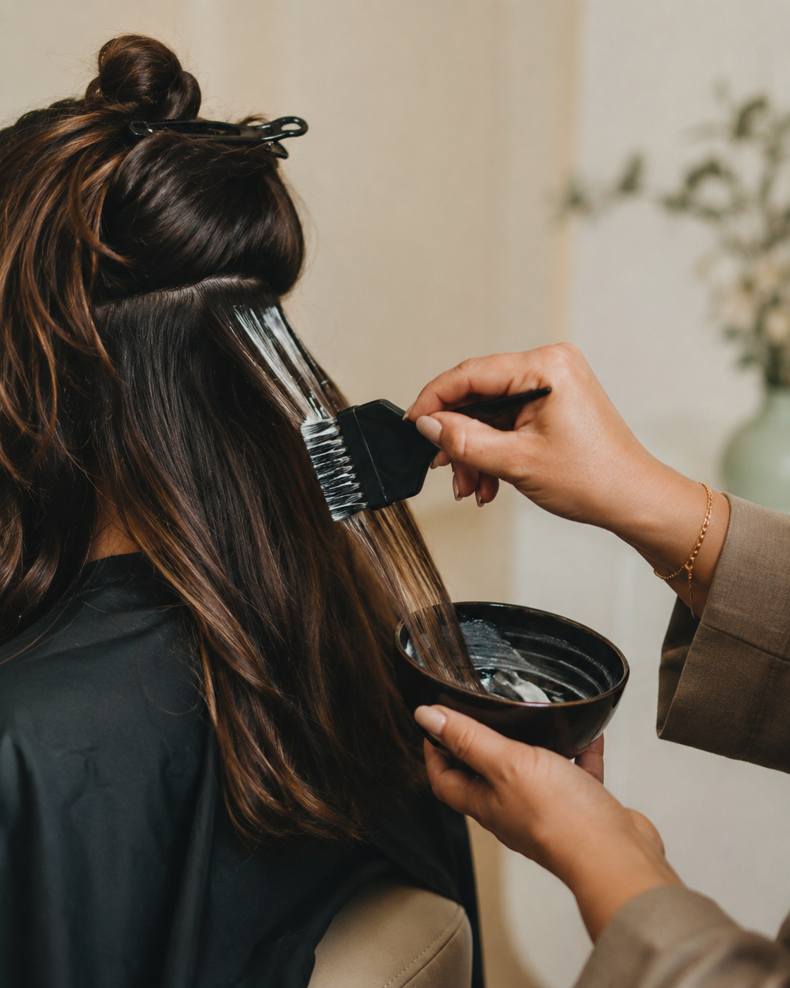Colourist applying tint to a client's hair